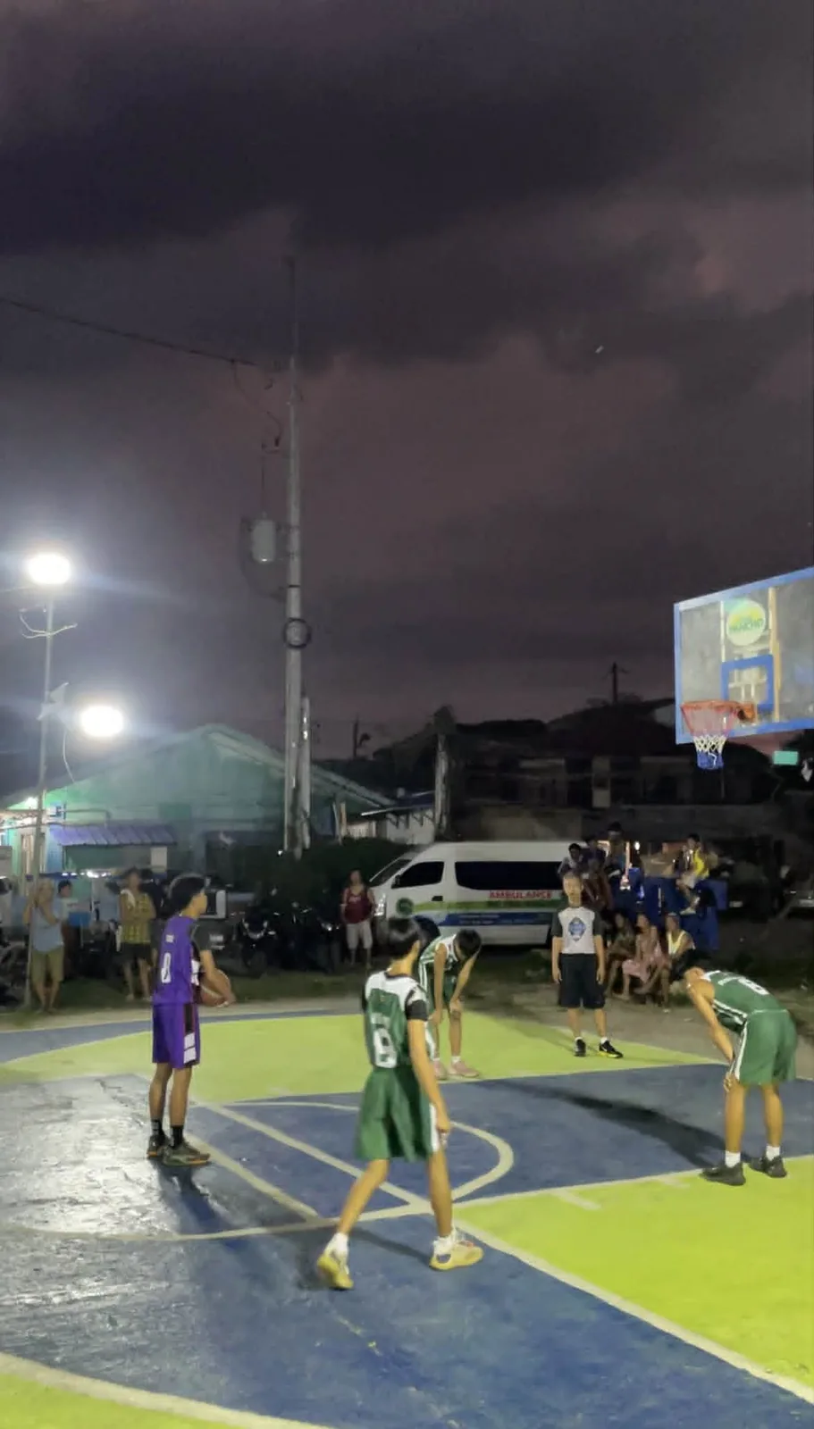 An outdoor basketball court at night